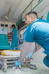 Health technician pulling a stretcher out of an ambulance