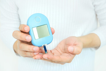 hand of people check diabetes and high blood glucose monitor with digital pressure gauge. Healthcare and Medical concept.