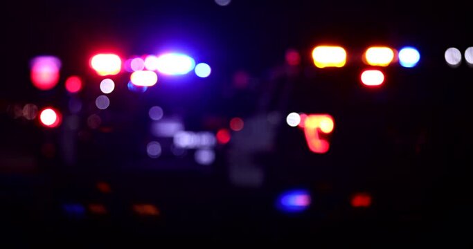 Abstracted night time bokeh view of police units responding to the scene of an emergency.