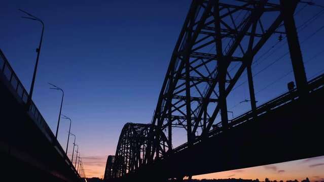 Up view of the bridge during sunset twilight sky. Shadows on the water surface.