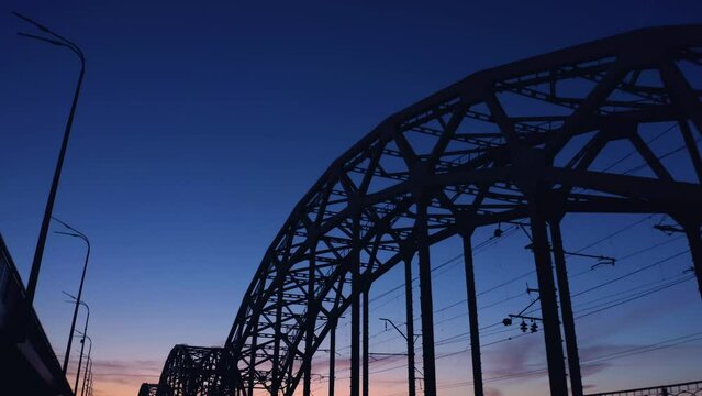 Up view of metal bridge frame arch. Blue twilight sky.