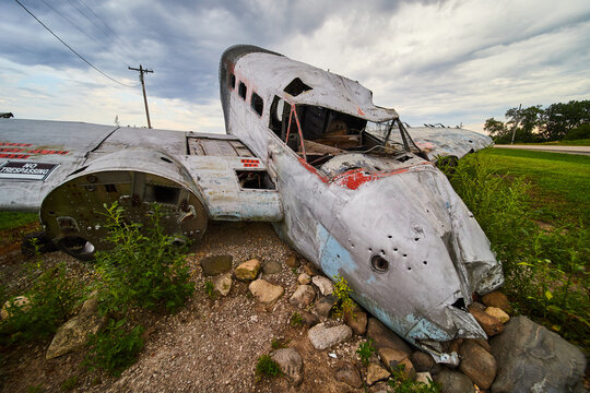 Old abandoned crashed plane in fields on cloudy day