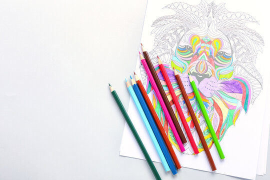Coloring page and pencils on light background