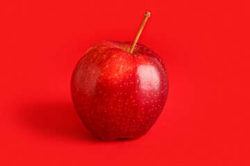 Ripe apple on red background