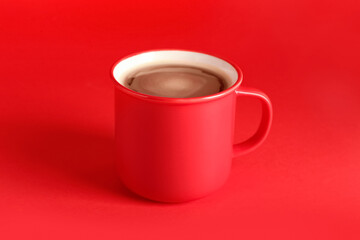 Cup of aromatic coffee on red background
