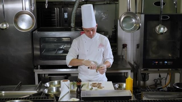Close-up of the chef peeling and cutting a large king prawn with a knife in the restaurant kitchen. Preparing a delicious dish with shrimp in a professional kitchen.