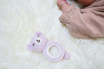 赤ちゃんの手とピンクのクマのおもちゃ