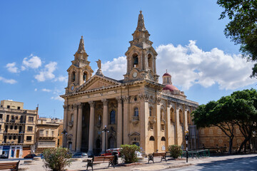 Fototapeta na wymiar The statue of Christ the King on the top of the façade of the Saint Publius, also known as the Floriana, Parish Church - Floriana, Malta