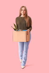 Fired young woman holding box with personal stuff on pink background