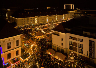 Christmas market in Magdeburg, Saxony-Anhalt with lots of light and people and different stalls. 