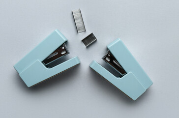 Office staplers and staples on light background