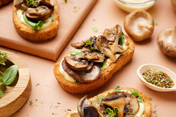 Tasty toasts with cream cheese and mushrooms on beige background, closeup