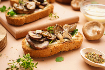 Tasty toasts with cream cheese and mushrooms on beige background, closeup
