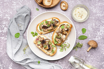 Plate of tasty toasts mushrooms and bowl of sauce on grunge background