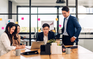 Group of asian business meeting and discussing strategy startup project analysis finance process.Success business people work plan and brainstorm marketing idea with laptop in office.Teamwork