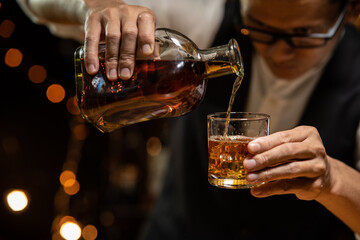 Barman pouring whiskey whiskey glass 