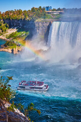 Misty Niagara Falls with rainbow and tourist ship near Horseshoe Falls - obrazy, fototapety, plakaty