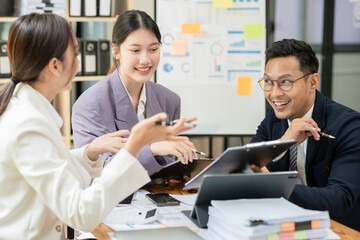 Group of asian business people working, discussing new projects together, having fun at the office.