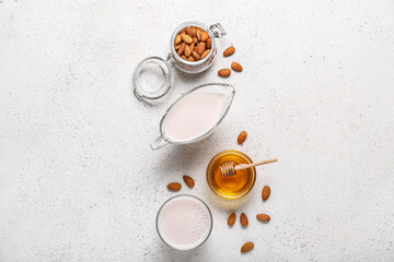 Obraz na płótnie Canvas Composition with healthy almond milk, nuts and honey on light background
