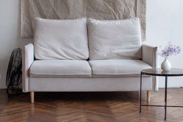 Retro interior with white sofa. White chair and wooden floor.