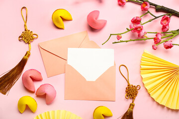 Envelopes with blank card, fortune cookies, Chinese symbols and sakura on pink background. New Year celebration