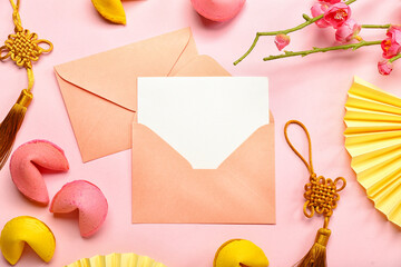 Envelopes with blank card, fortune cookies, Chinese symbols and sakura on pink background. New Year celebration