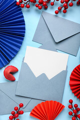 Envelopes with blank card, fortune cookie and Chinese symbols on blue background. New Year...