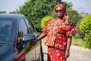 image of african woman besides automobile- beautiful black mother holding car door