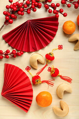 Fortune cookies, mandarins and Chinese symbols on wooden background. New Year celebration