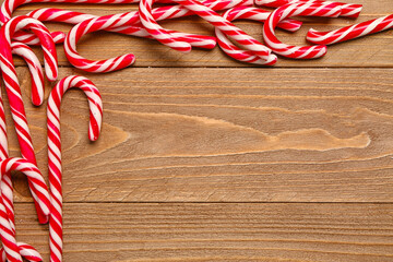 Composition with sweet candy canes on wooden background