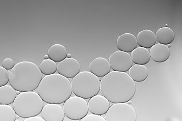 Abstract oil  drops on water surface on grey gradient background.
