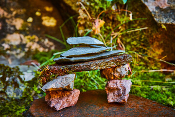 Cairn stone stack structure tiny scene against moss and lichen-covered rocks