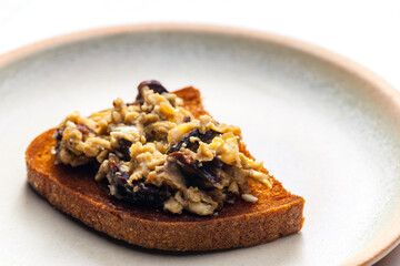 roasted bread served with scrambled eggs and mushrooms
