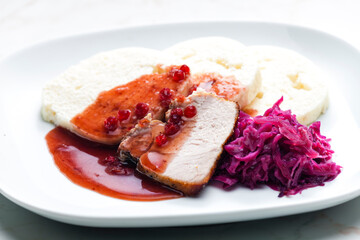 pork meat with red cabbage, cranberry sauce and dumplings