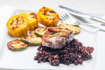 grilled pork steak with zucchini and corn served with black quinoa