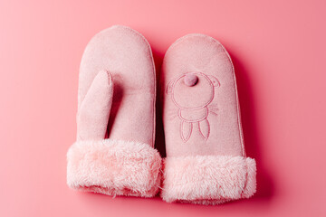 Pink mittens against pink background studio shot