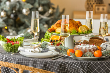 Christmas table setting with tasty chicken and glasses of champagne in dining room