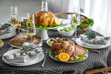 Christmas table setting with tasty ham and glasses of champagne in dining room