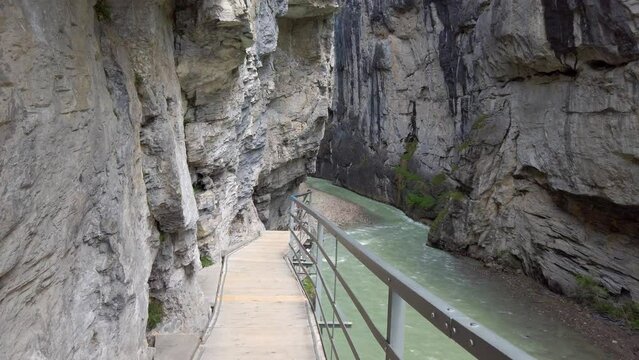 View of a hiker in a ravine on a running trail. It is the Aare Gorge in Meiringen Canton Bern