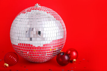 Disco ball with Christmas toys on red background