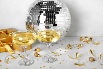 Glasses of champagne, Christmas balls and gifts on white background
