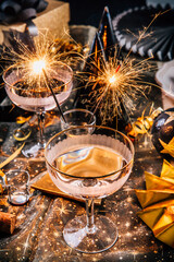 Happy New Year - two glasses of champagne with sparkler on decorated festive table