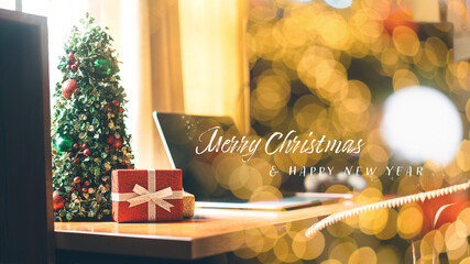 Christmas tree and wapped present boxing decorated on wooden work table with text for new year holidays