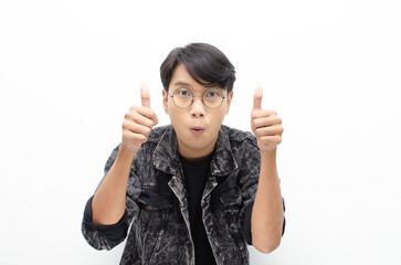 handsome attractive Asian man wearing jeans jacket smiling happily and giving thumbs up as...