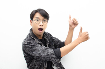 handsome attractive Asian man wearing jeans jacket smiling happily and giving thumbs up as...