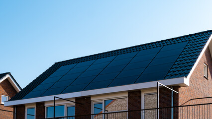 Newly build houses with black solar panels attached to the roof 