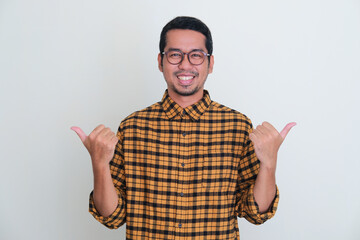 Adult Asian man smiling at camera with both hand pointing to the right and left direction