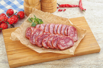 Sliced salami sausages over board
