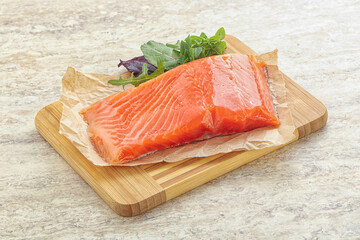 Raw salmon fillet over board