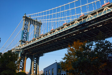 Looking up at Manhattan Bridge in Brooklyn New York City with blue sky